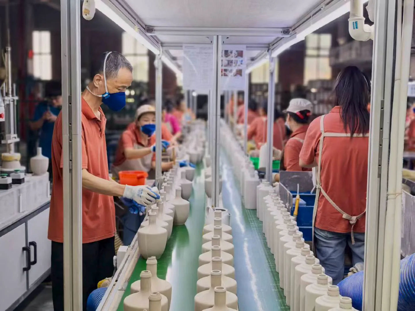 Skilled workers inspecting and finishing ceramic vases on a Liling factory production line